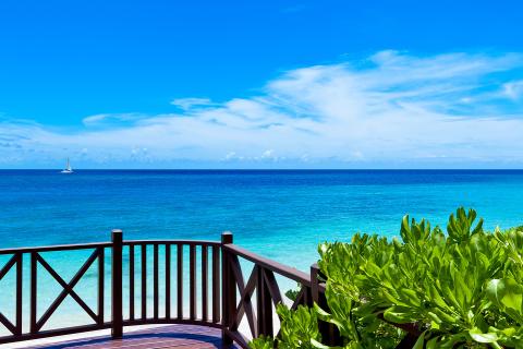 This image shows a beautiful seascape viewed from a wooden deck