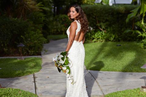 The image features a woman in an elegant white lace wedding dress, looking over her shoulder