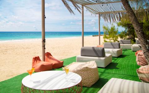 This image shows a serene beachfront setting with a luxurious relaxation area