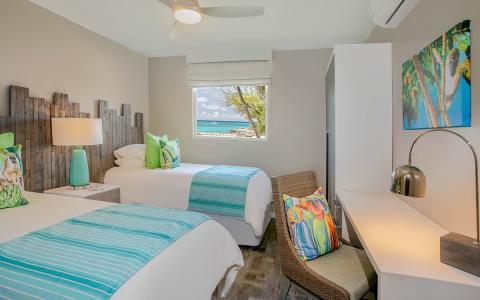 The image shows a bright and well-decorated beach-themed hotel or resort room