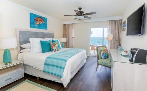 The image shows a stylishly decorated beachfront hotel room