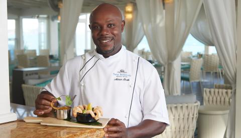 This image features a chef standing in a restaurant