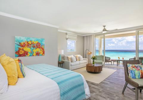 This image shows a bright and stylishly decorated room with a clear view of the ocean