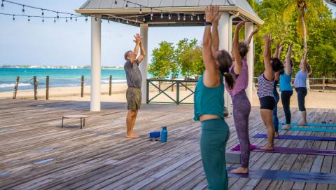 people doing yoga on a pier