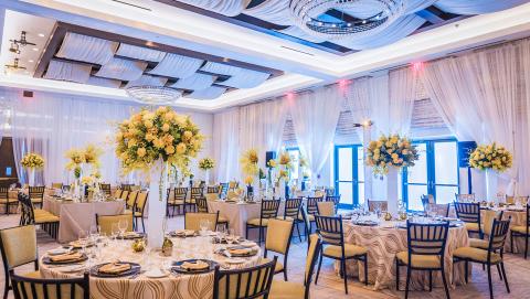 This image shows an elegantly decorated banquet hall suitable for a formal event such as a wedding reception or a gala dinner