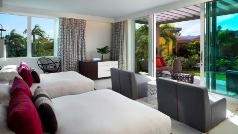 bungalow beadroom with two beds and patio