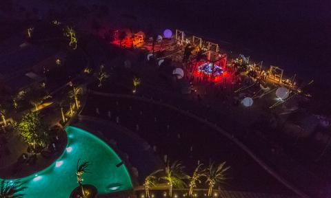 This image depicts a nighttime scene at an upscale outdoor event or gathering area, likely a resort or similar venue