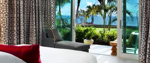 This image captures a serene and inviting room with a view of the ocean