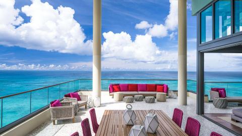 This image shows a luxurious outdoor terrace with a stunning ocean view