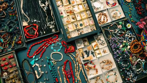 This image displays a vibrant and diverse collection of jewelry displayed over a dark background
