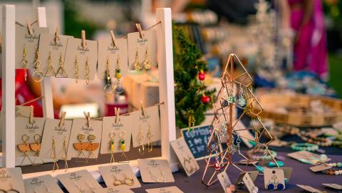 This image showcases a variety of handmade jewelry displayed in a market setting
