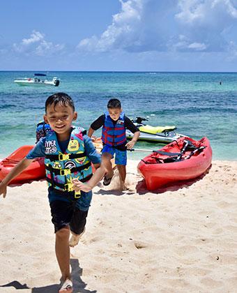 The image shows two young boys on a sandy beach