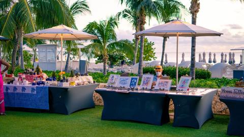 This image displays an outdoor market or fair setup by the beach during twilight