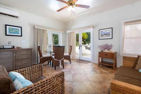 This image shows a bright and welcoming living room area leading into a dining space