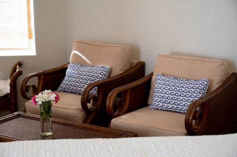 The image features a nicely arranged interior room with two vintage-style wooden armchairs
