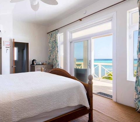 The image shows a bedroom in a coastal or beachside house or hotel