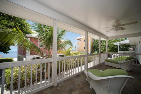 This image shows a cozy, covered outdoor porch area overlooking a scenic view