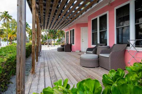 This image shows an inviting outdoor patio area of a pink-painted building