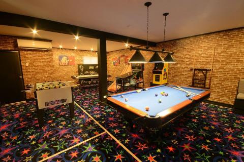 The image shows a vibrant game room equipped with various recreational games