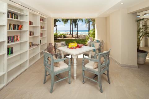 This image features an indoor area that seamlessly transitions into a beautiful beachfront view