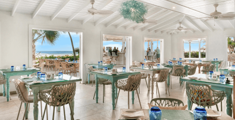 This image shows an inviting and beautifully arranged beachfront dining area in a restaurant