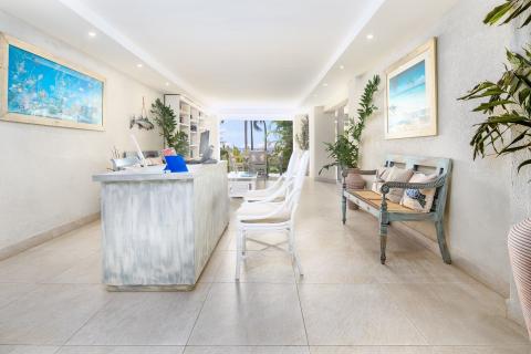 This image shows a bright and airy indoor reception area of what appears to be a resort or hotel
