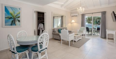 The image shows a modern and well-furnished interior of a room that likely serves as both a dining and living area