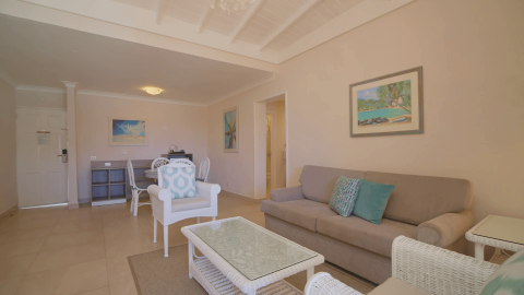 This image shows a well-lit, spacious living room with a tropical or coastal decorating theme