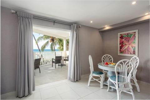 The image shows a neatly decorated indoor-outdoor space, likely a part of a beachside property