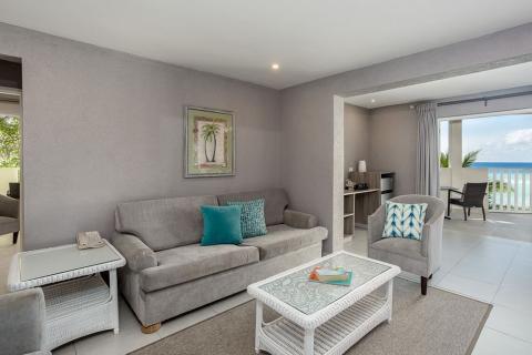 This image shows a modern and neatly arranged living room with a coastal view
