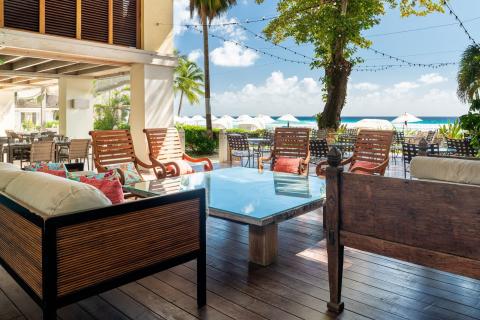 This image features an open, stylish outdoor patio area of a coastal resort