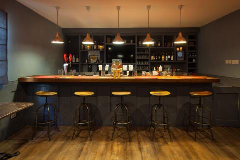 The image depicts the interior of a stylish bar