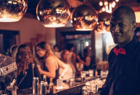 The image captures a bustling bar scene