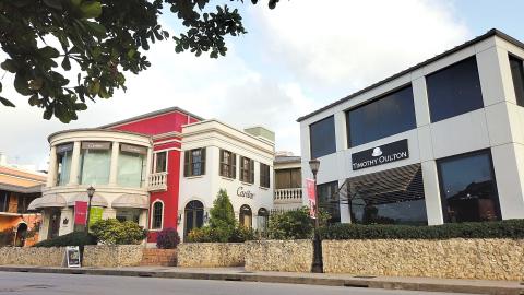 The image shows a street view with different retail shops and buildings