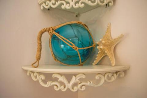 The image shows a nautical-themed decorative setup on a white ornamental shelf
