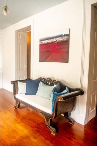The image displays a well-lit room with gleaming hardwood floors and a vintage aesthetic