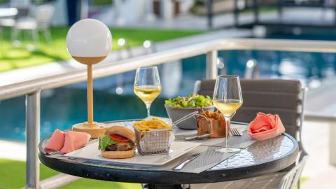 This image shows an outdoor dining setup near a pool