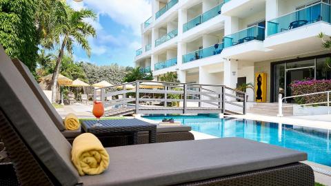 This image displays a luxurious resort setting with a poolside view
