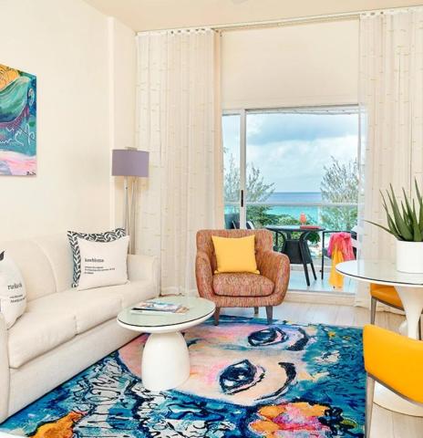 This image features a cozy, stylish living room with a vibrant beachfront view