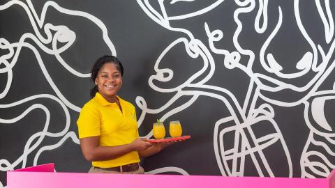 This image features a smiling woman wearing a bright yellow shirt