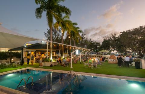 This image shows a lively outdoor evening scene at a leisure venue, possibly a bar or a resort