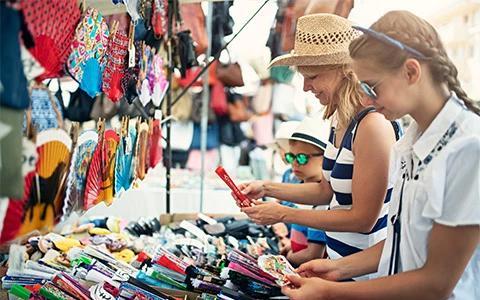 This image shows a family shopping at an outdoor market