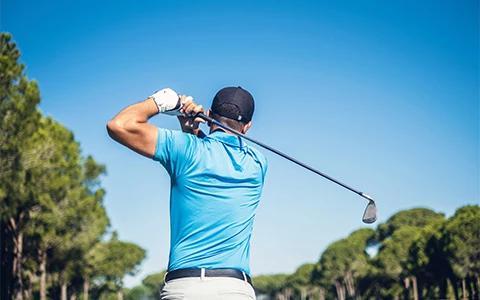 The image shows a golfer mid-swing on a golf course