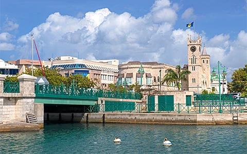 The image shows a scenic waterfront with a bridge and some architectural features that include modern and historical buildings