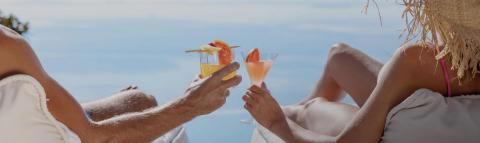 The image captures a relaxing scene featuring two people lounging in the sunlight, seemingly on vacation