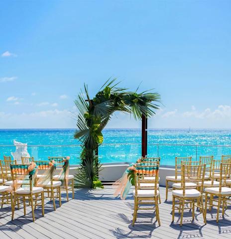 This image features an outdoor setting prepared for a special event, likely a wedding ceremony, given the elegant setup